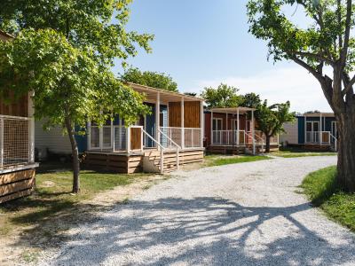 Small colorful houses with porches, surrounded by trees.