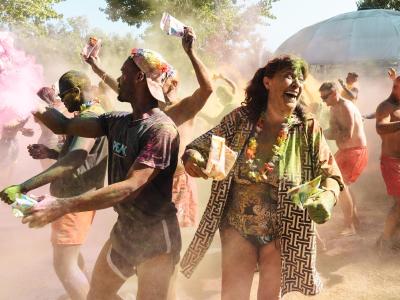 People celebrating with colored powders outdoors.