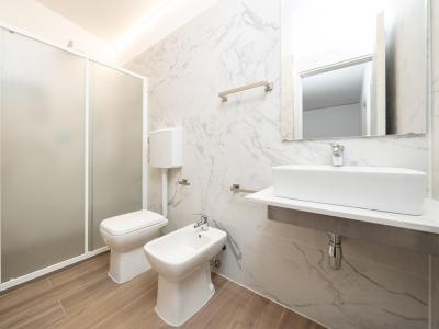 Bagno moderno con doccia, lavabo, bidet e WC.