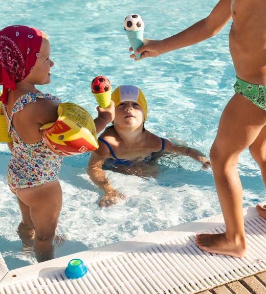 Bambini giocano in piscina con giocattoli colorati.