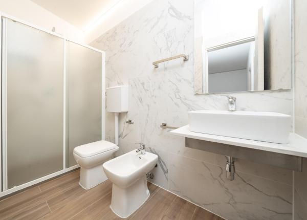 Bagno moderno con doccia, lavabo, bidet e WC.