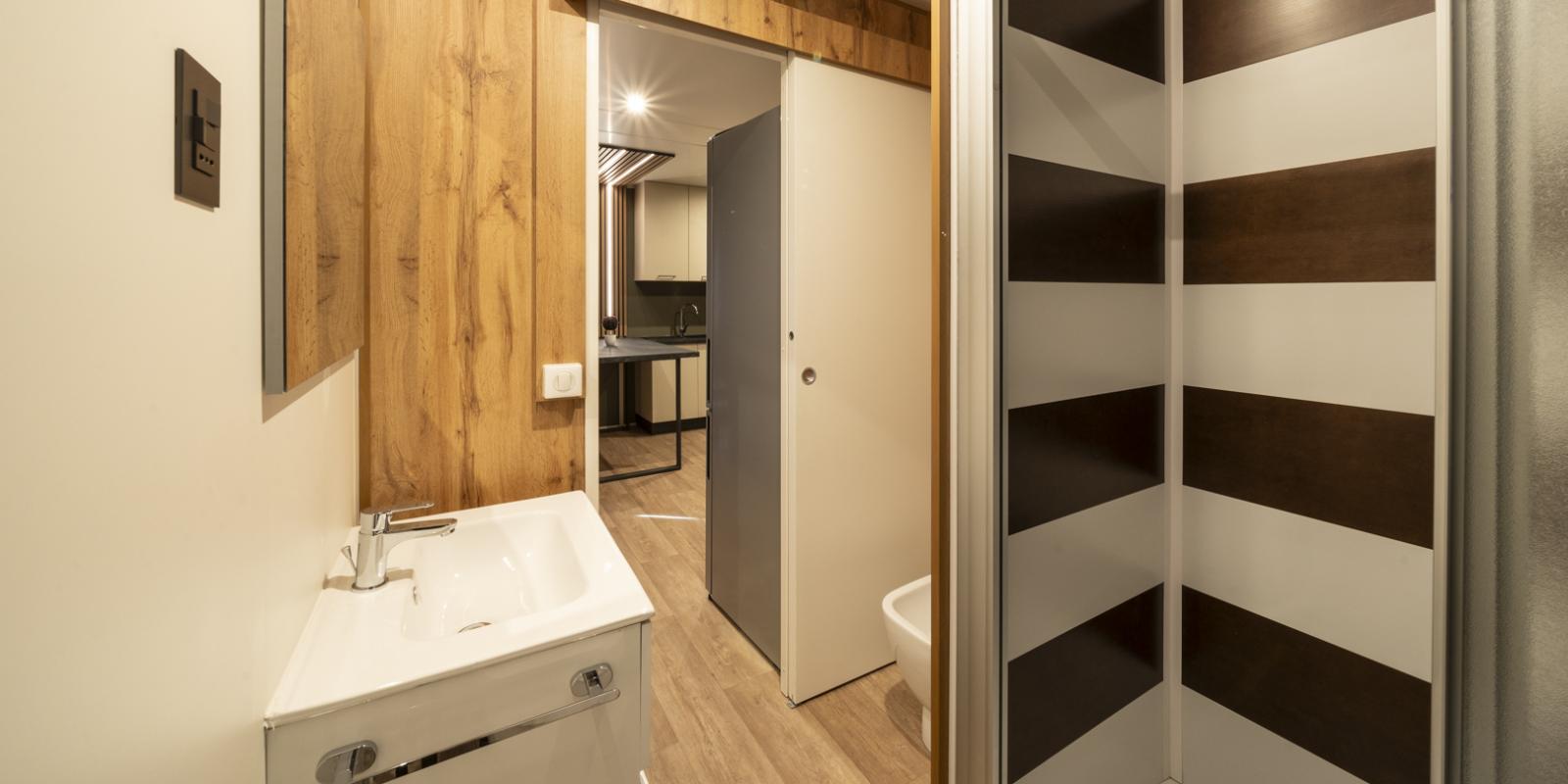 Bagno moderno con doccia e lavabo, legno alle pareti.