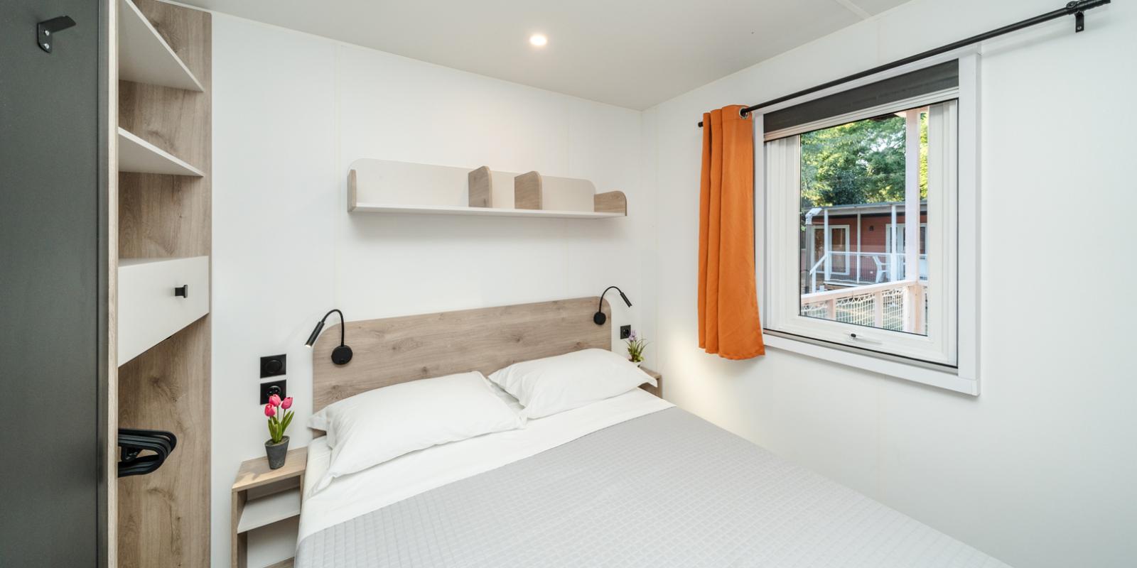 Modern bedroom with double bed and window.