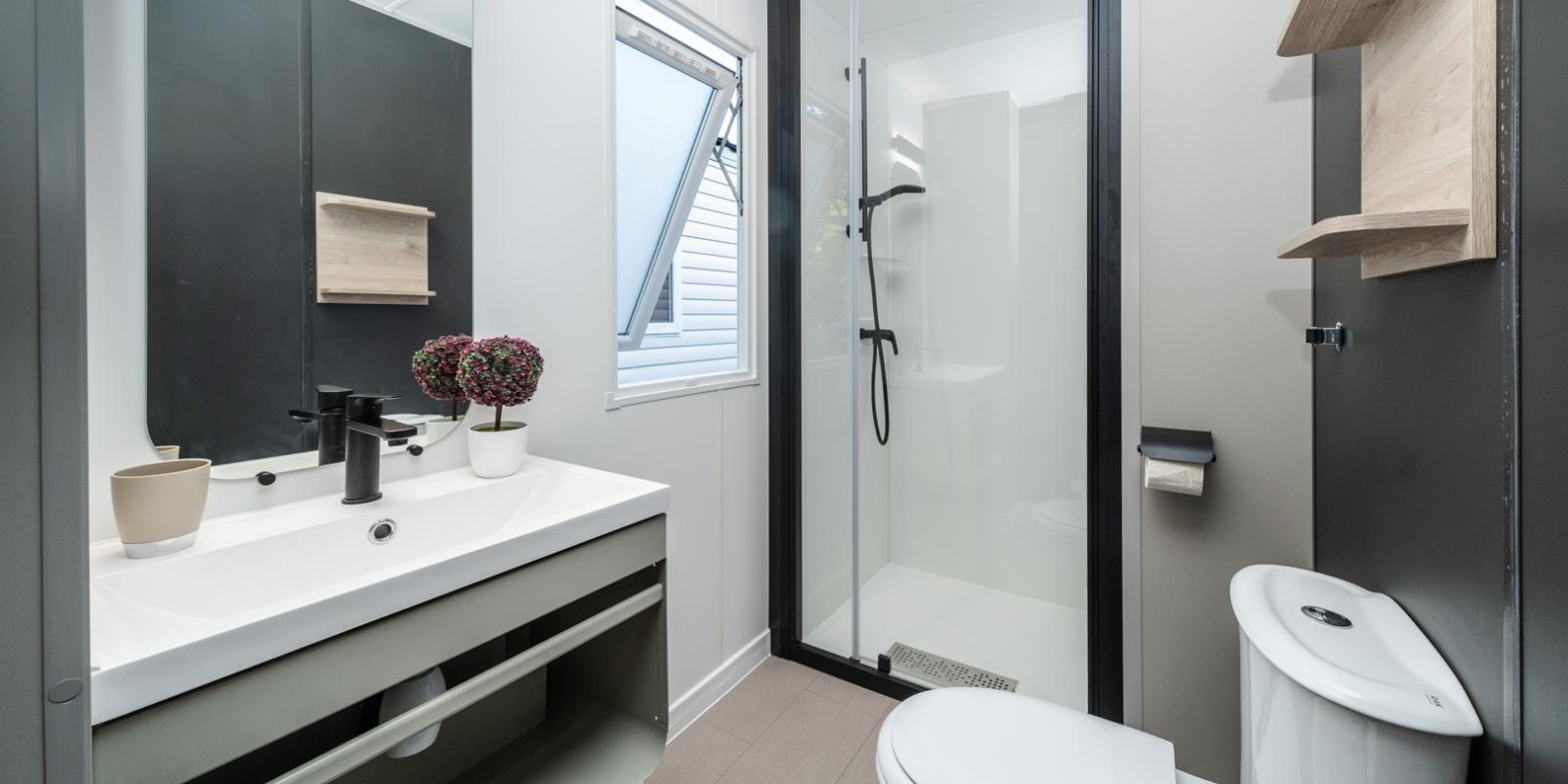 Modern bathroom with shower, sink, and toilet.