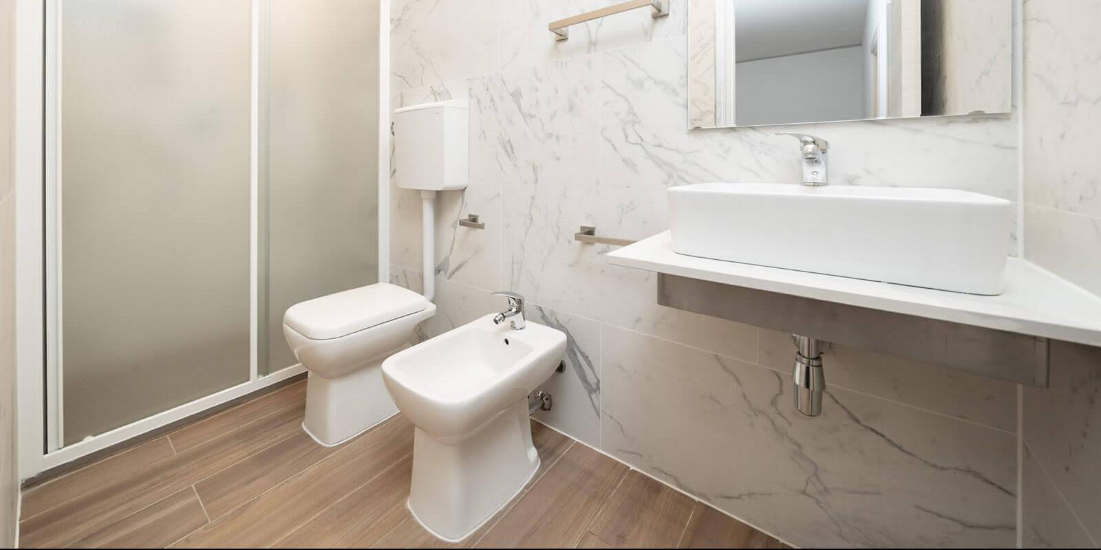 Bagno moderno con doccia, lavabo, bidet e WC.