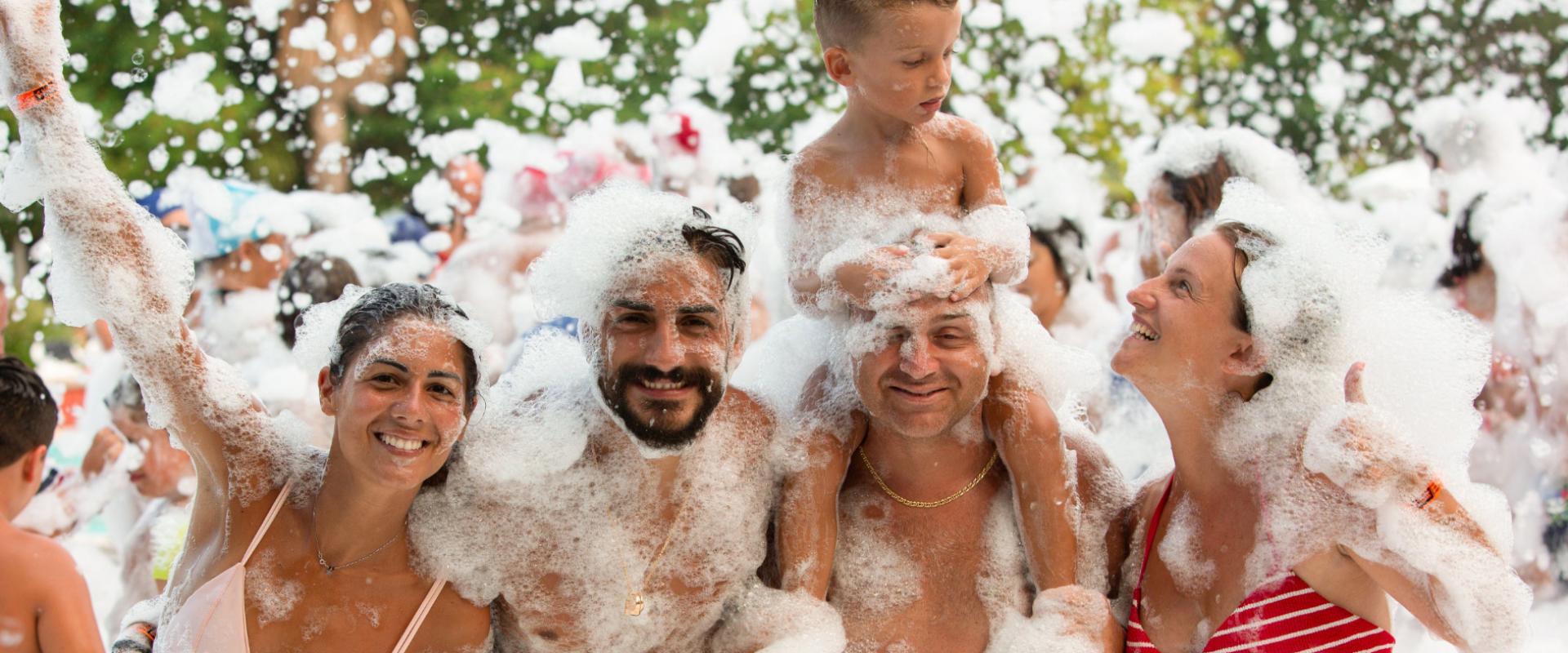 Persone che si divertono in una festa di schiuma all'aperto.