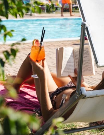 Relax in piscina con un libro e un cocktail rinfrescante.