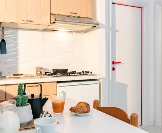 Cucina moderna con colazione pronta e vista su una camera da letto accogliente.