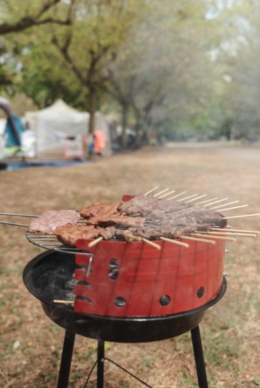 Barbecue all'aperto con carne alla griglia su spiedini e bistecche.